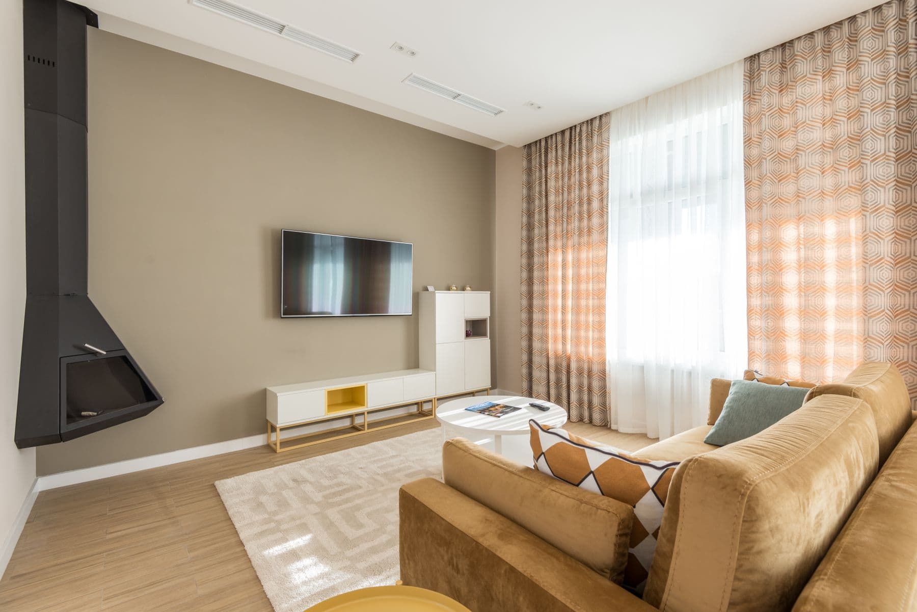 Wall-mounted TV on a warm gray wall with no visible cables, a low white console beneath it